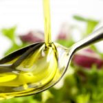 Растительное масло льется на столовую ложку