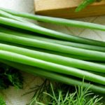 Зеленый лук возле разделочной доски рядом с укропом