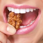 Девушка ест орехи